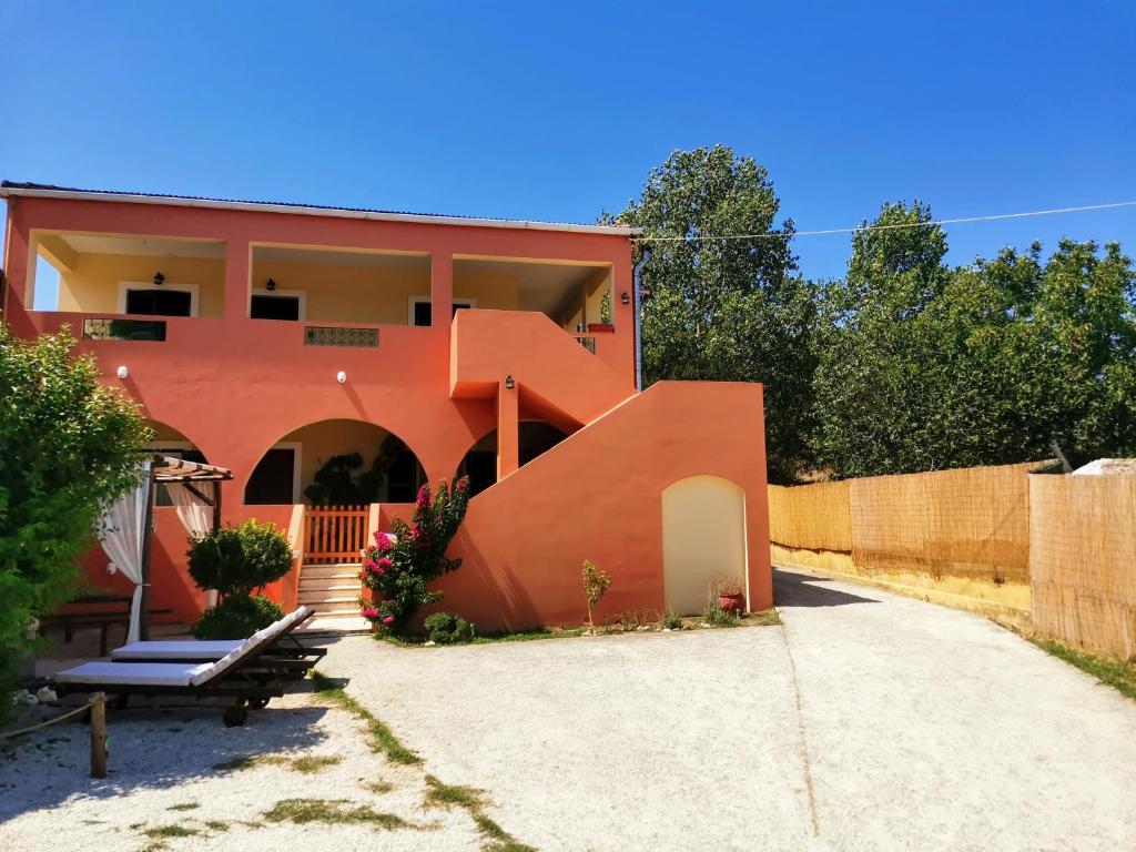 a orange house with a staircase in front of it at VILLA GREEN VALLEY in Velonádes