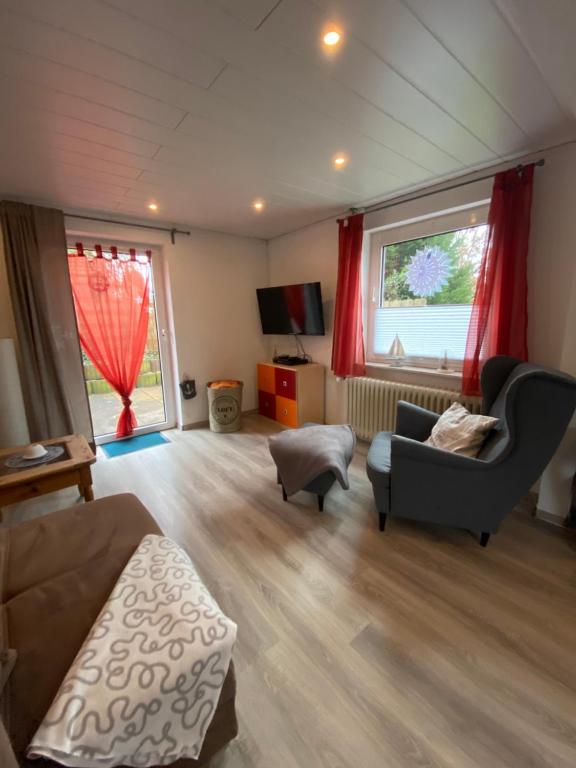 ein Wohnzimmer mit einem Sofa und einem Stuhl in der Unterkunft FeWo-Busche, Doppelhaushälfte mit Garten in Wittmund