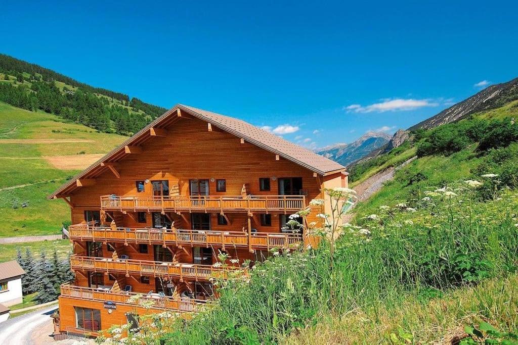 a large wooden building on the side of a hill at T2/3 6pers & pied des pistes & piscine chauffée in Vars