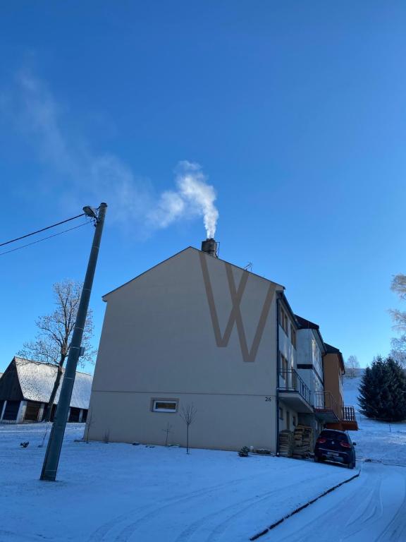 a white building with smoke coming out of it at W apartmán 2 in Teplice nad Metují
