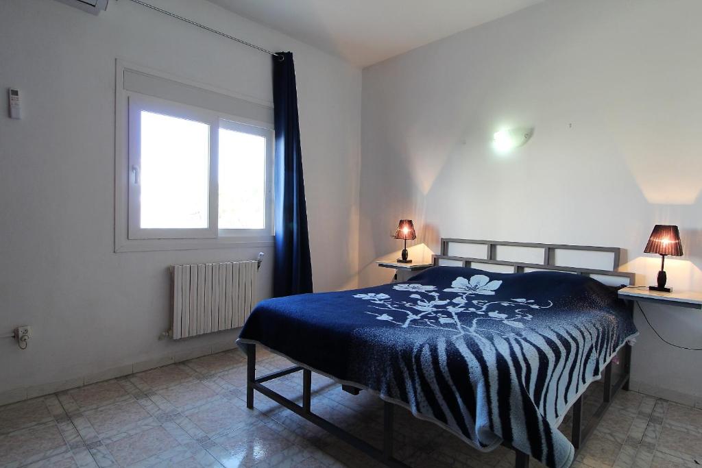 a bedroom with a blue bed and a window at Nice Holiday Apartment Hammam Sousse in Hammam Sousse