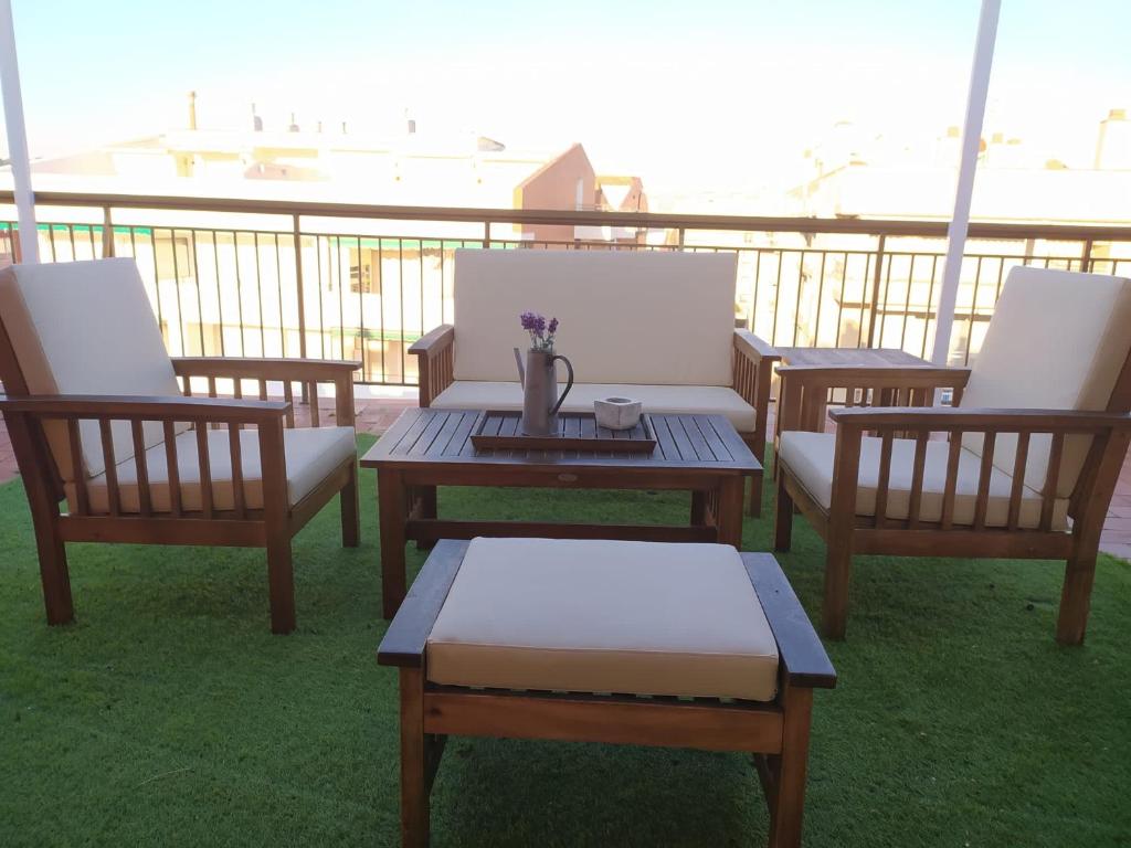 a group of chairs and tables on a balcony at Atico Isaac Albeniz in La Pineda