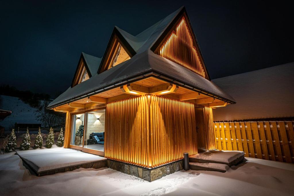 Górska Baja Premium House في فيتوف: مبنى صغير عليه انوار في الثلج