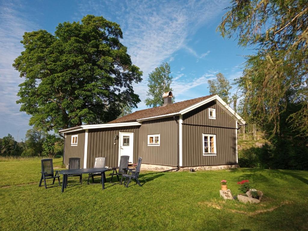cobertizo con mesa y sillas en un patio en Kilsborgs Gård - Lakehouse en Svanskog