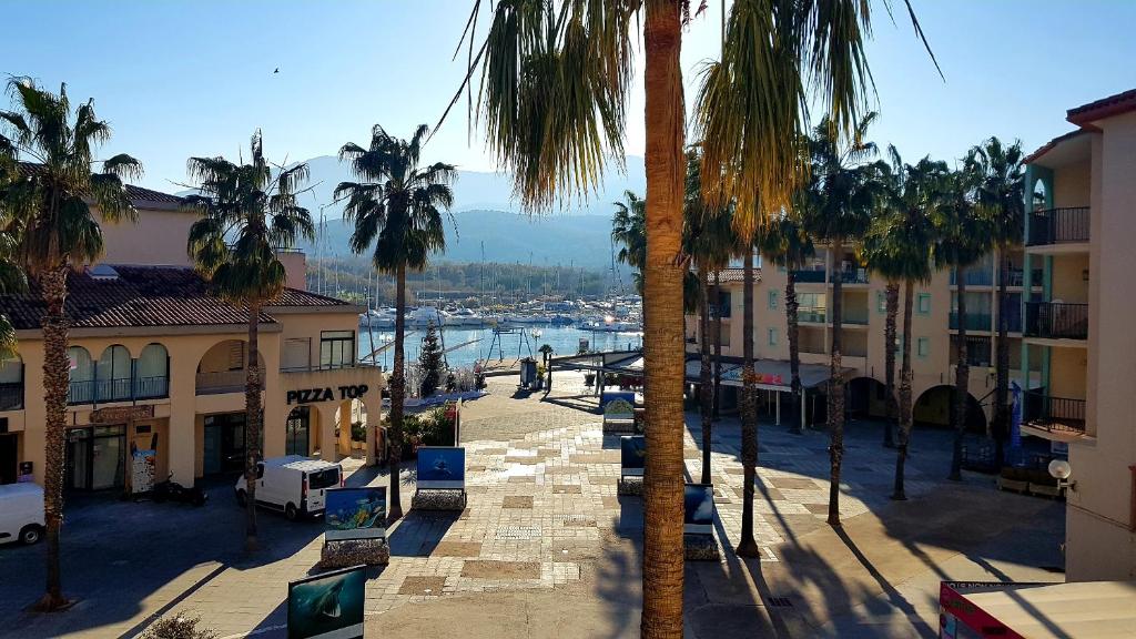 - une vue sur une rue bordée de palmiers et de bâtiments dans l'établissement La Cellie, à Plage dʼArgelès