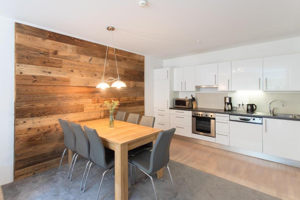 a kitchen and dining room with a wooden wall at Waterfall TOP 15 - NEW IMAGE 2022 in Bad Gastein