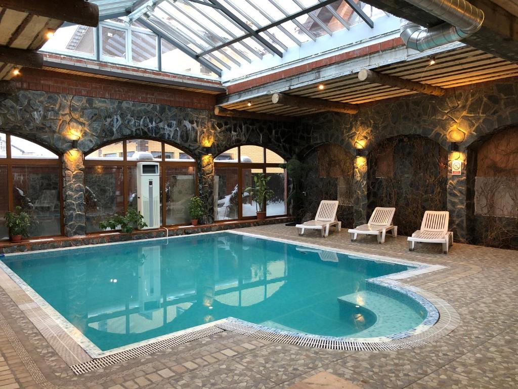 a swimming pool in a building with a glass ceiling at Guest House Valeria in Velikiy Novgorod