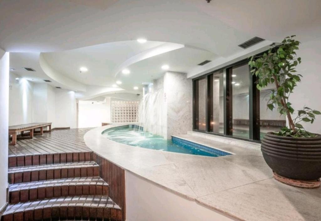 瓜魯柳斯的住宿－Guarulhos flat services, aeroporto，一座带楼梯的大楼内的游泳池,通往游泳池