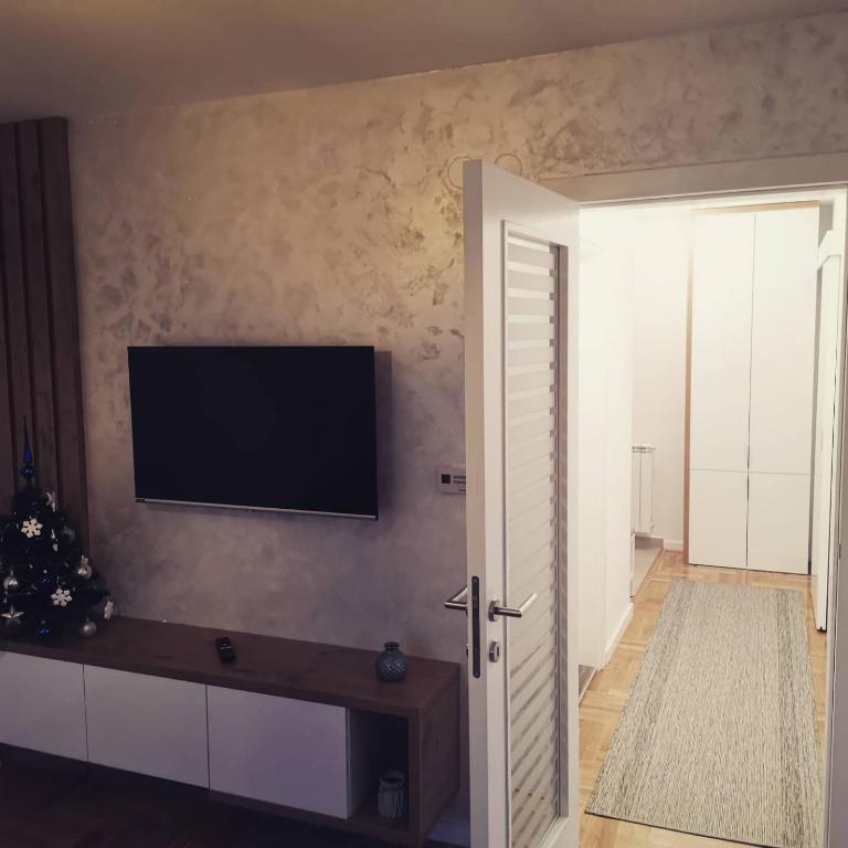 a living room with a flat screen tv on the wall at Apartman Casa Lukavica Istočno Sarajevo in Lukavica