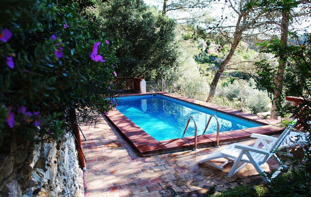 a swimming pool with a chair and a table at Mountain Finca with Pool in Puigpunyent