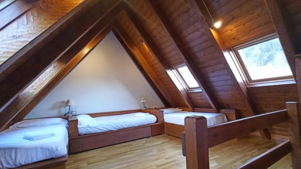 duas camas no sótão de um chalé de madeira em Tredós, Casa adosada. Baqueira em Tredós