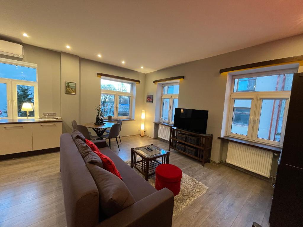 sala de estar con sofá, TV y mesa en Senamiescio Tiltu apartamentai, en Klaipėda