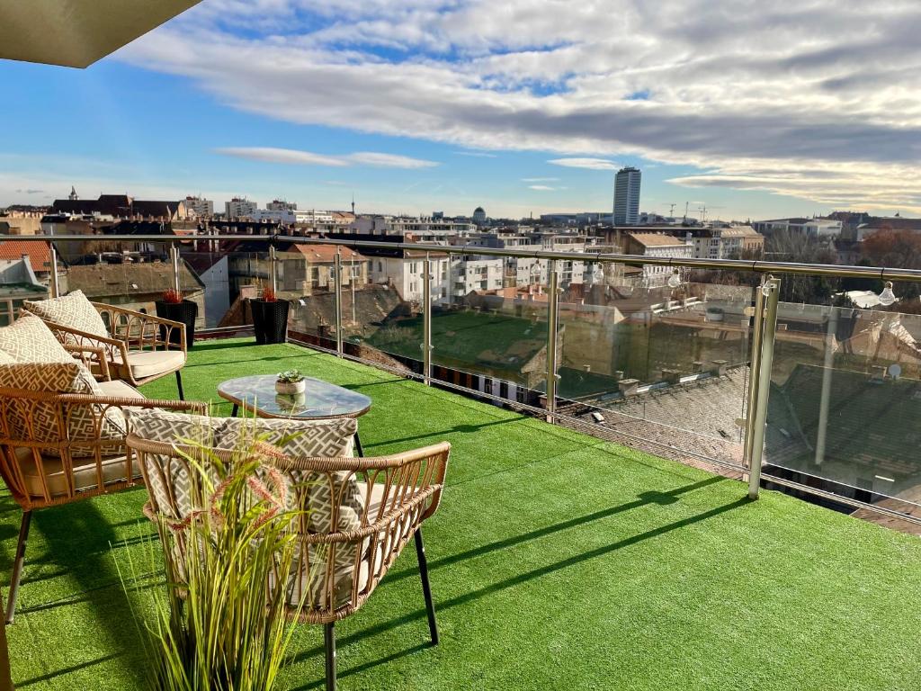 a balcony with green grass and a table and chairs at Downtown Penthouse Budapest in Budapest