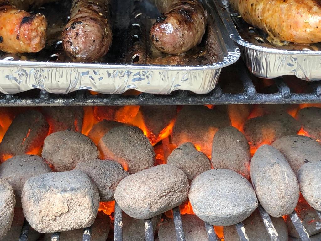 a bunch of meat and sausages on a grill at Forest Lodge in Petit Mesnil