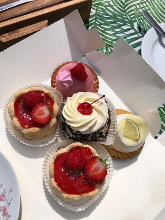 a group of four cupcakes with strawberries and whipped cream at Forest Lodge in Petit Mesnil