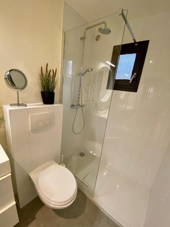 a bathroom with a toilet and a glass shower at Forest Lodge in Petit Mesnil