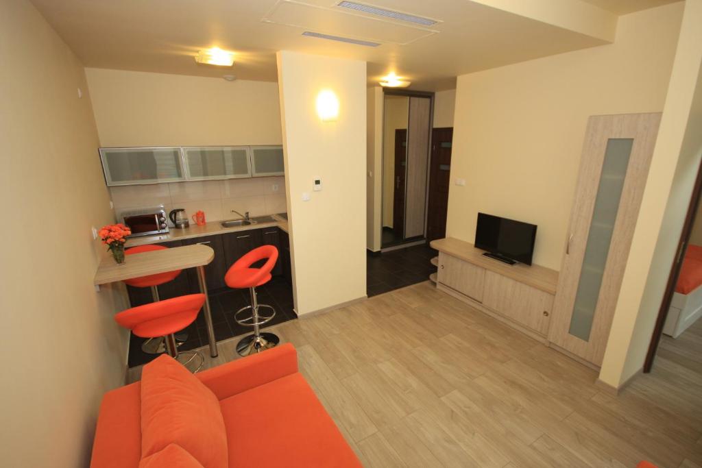 sala de estar con sofá naranja y cocina en Asha, en Cracovia
