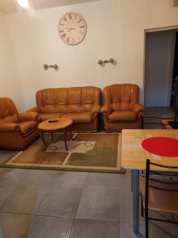 - un salon avec des canapés en cuir et une horloge murale dans l'établissement Appartement meublé avec deux chambres, à Moulins