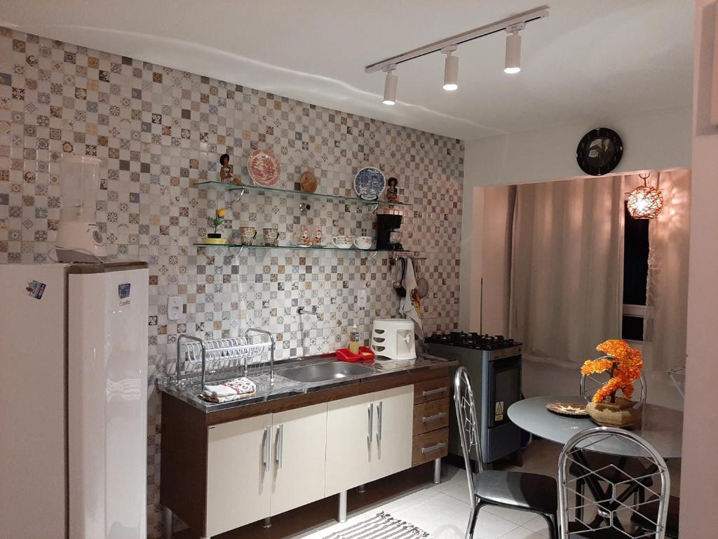 a kitchen with a sink and a table and a refrigerator at Apartamento 2 Bairro Boa Vista 1 in Caruaru