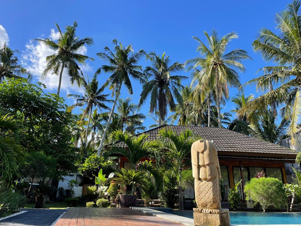 een resort met een standbeeld voor een zwembad bij Red island villas in Banyuwangi