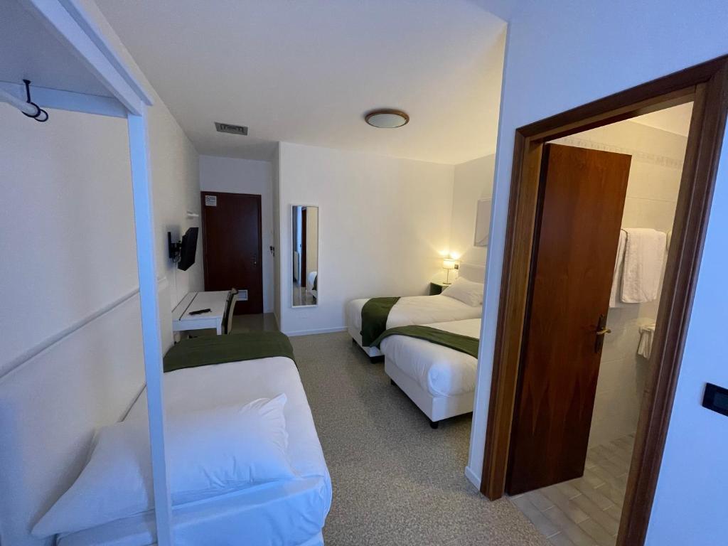 Pokój hotelowy z 2 łóżkami i lustrem w obiekcie Casa Valcellina Hotel Ristorante w mieście Montereale Valcellina