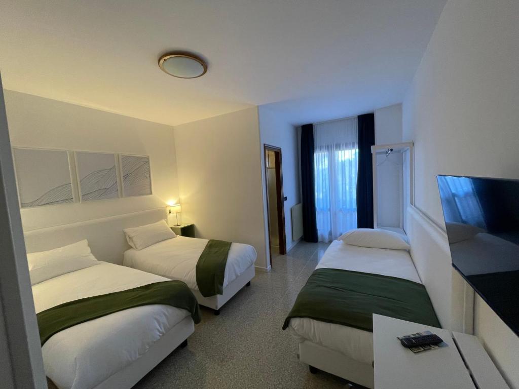 pokój hotelowy z 2 łóżkami i telewizorem z płaskim ekranem w obiekcie Casa Valcellina Hotel Ristorante w mieście Montereale Valcellina