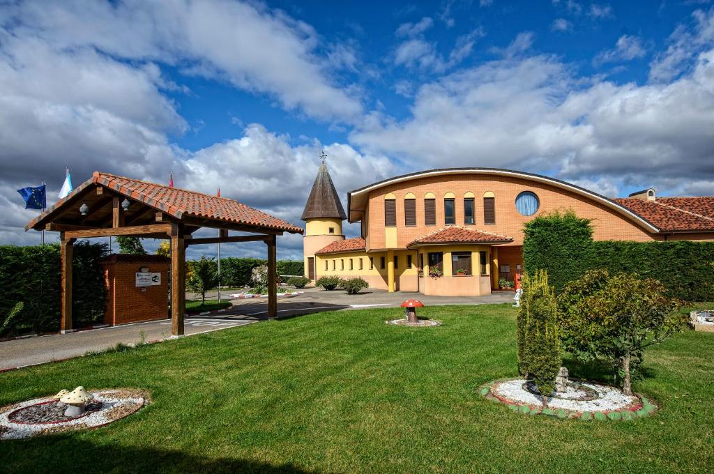 a large building with a grass yard in front of it at Motel Cancun León in Ardón