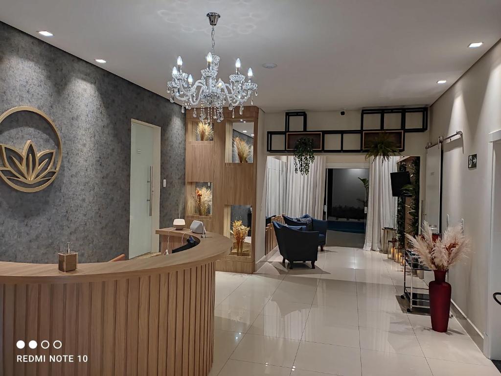 een lobby van een salon met een kroonluchter bij Prosper Executive Hotel in Capivari