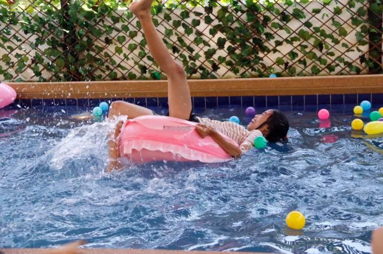 a young girl laying on an inner tube in a swimming pool at Ponly Pool Villa Huahin 4 Bedroom With BBQ Facilities & Karaoke For 8-20 Pax in Hua Hin