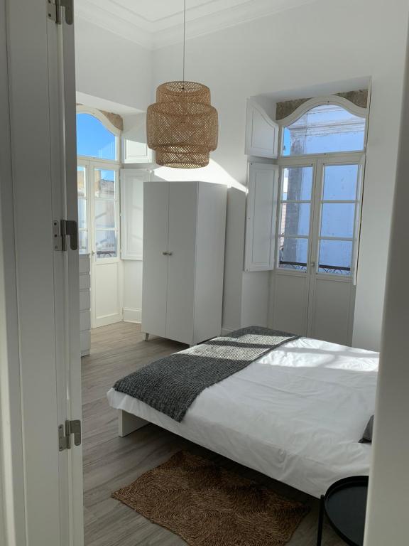 a bedroom with a bed and a pendant light at Casa Cubista in Olhão