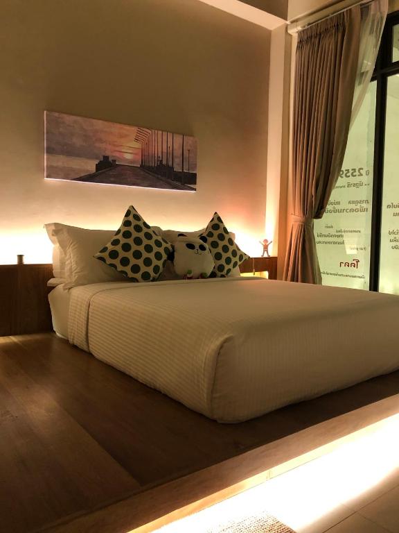 a bedroom with a large bed with pillows on it at Yellow door Hua Hin in Hua Hin