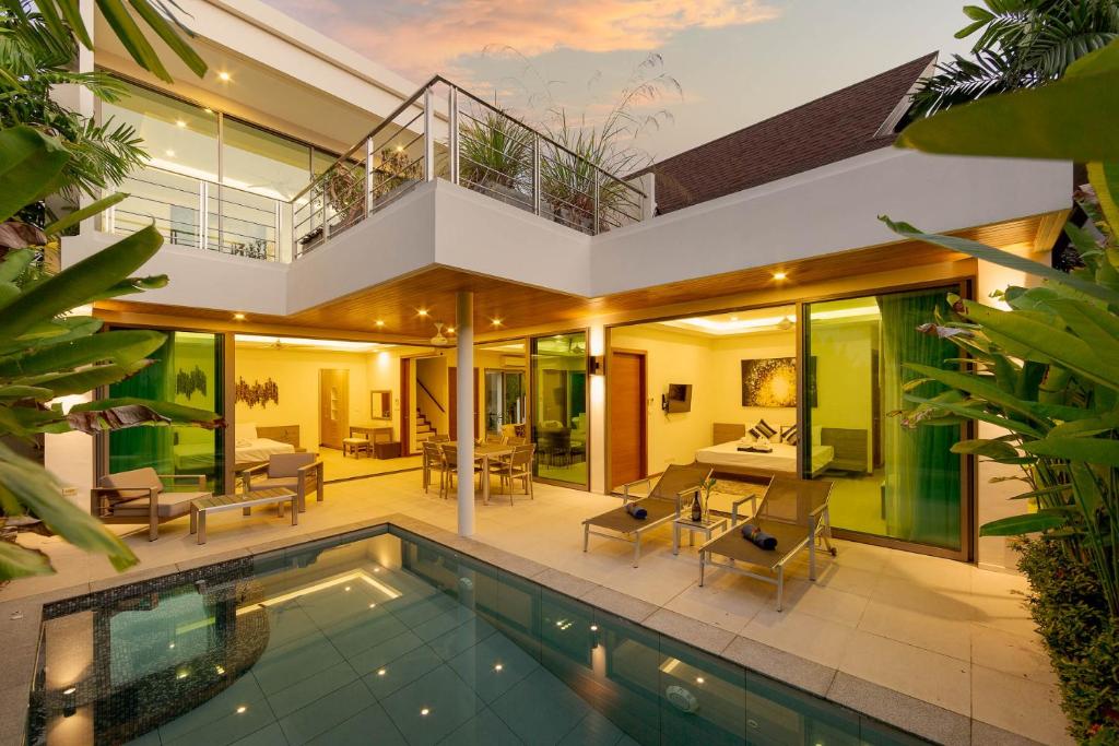 a villa with a swimming pool and a house at Laem Ka Residence by Tropiclook in Rawai Beach