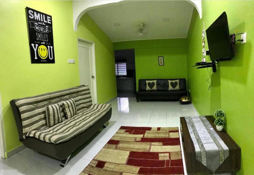 a living room with green walls and a couch at Kinaz homestay in Ipoh