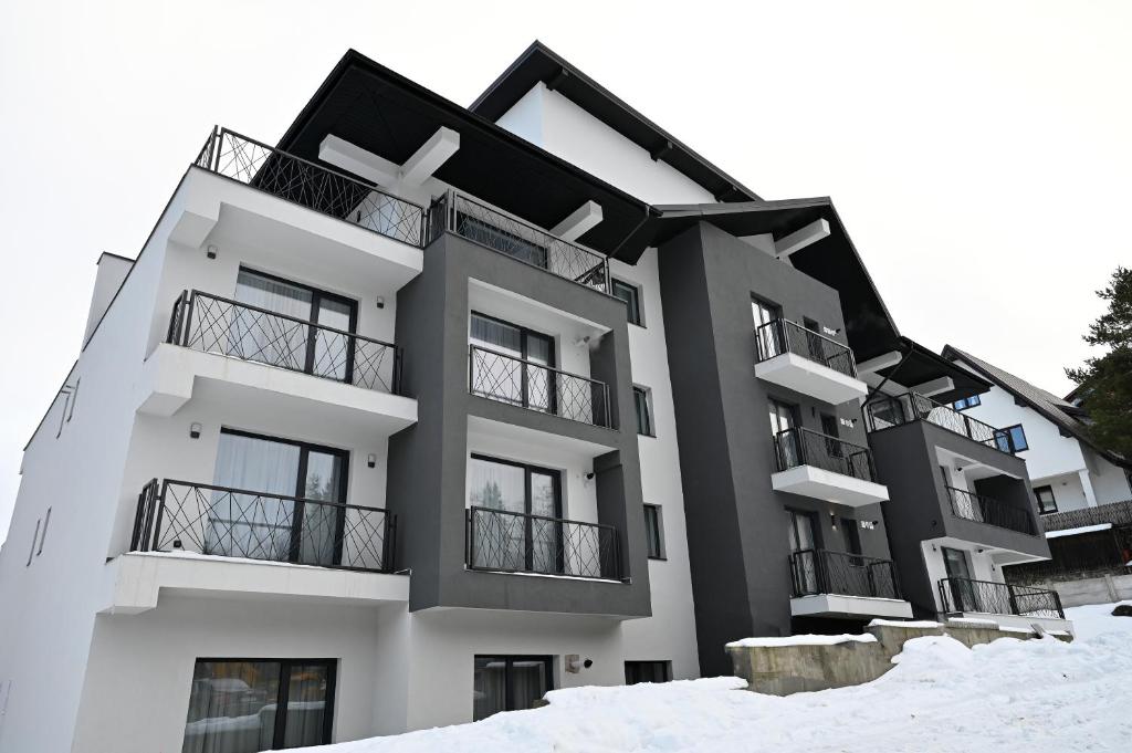 un edificio con nieve delante en R&B Apartments, en Predeal