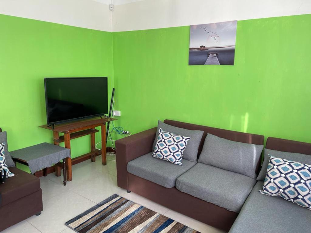 a living room with a couch and a flat screen tv at Green bay 2 in Pereybere