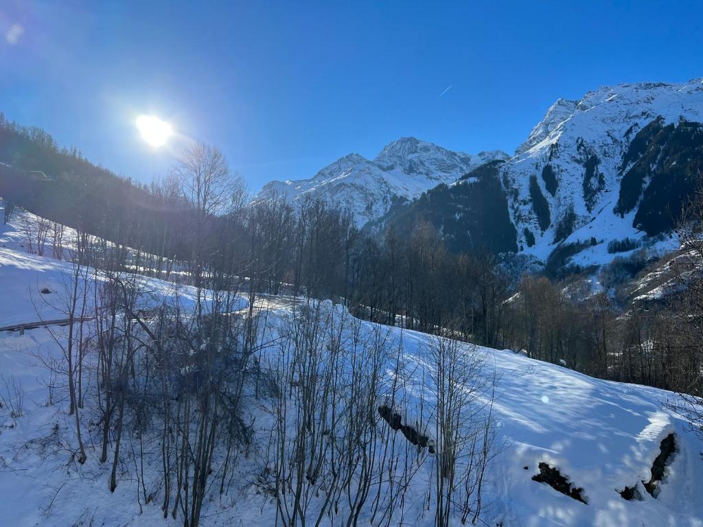 a snow covered mountain with the sun in the background at Chalet Altus in Sainte-Foy-Tarentaise