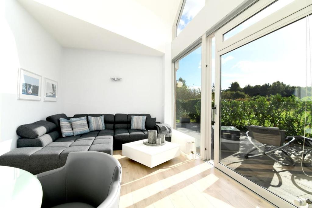 a living room with a couch and a large window at Exklusives Ferienhaus mit Schwimmbad und Sauna in Grömitz