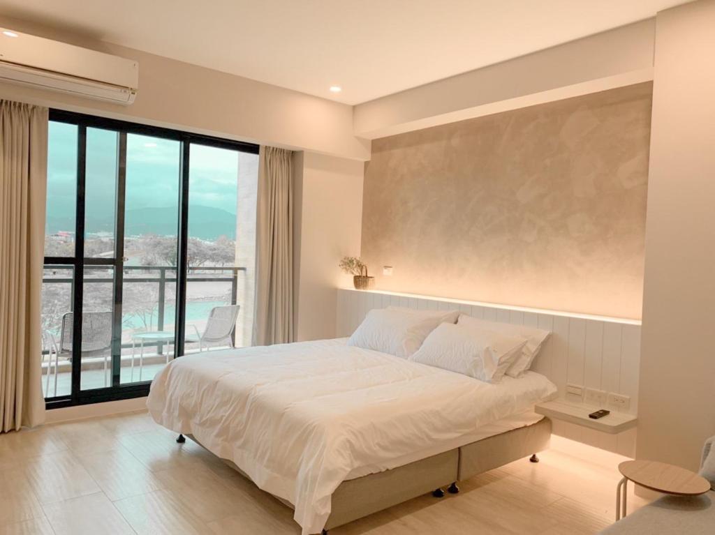 una camera con un grande letto e una grande finestra di 如沐咖啡旅宿 a Xingjian