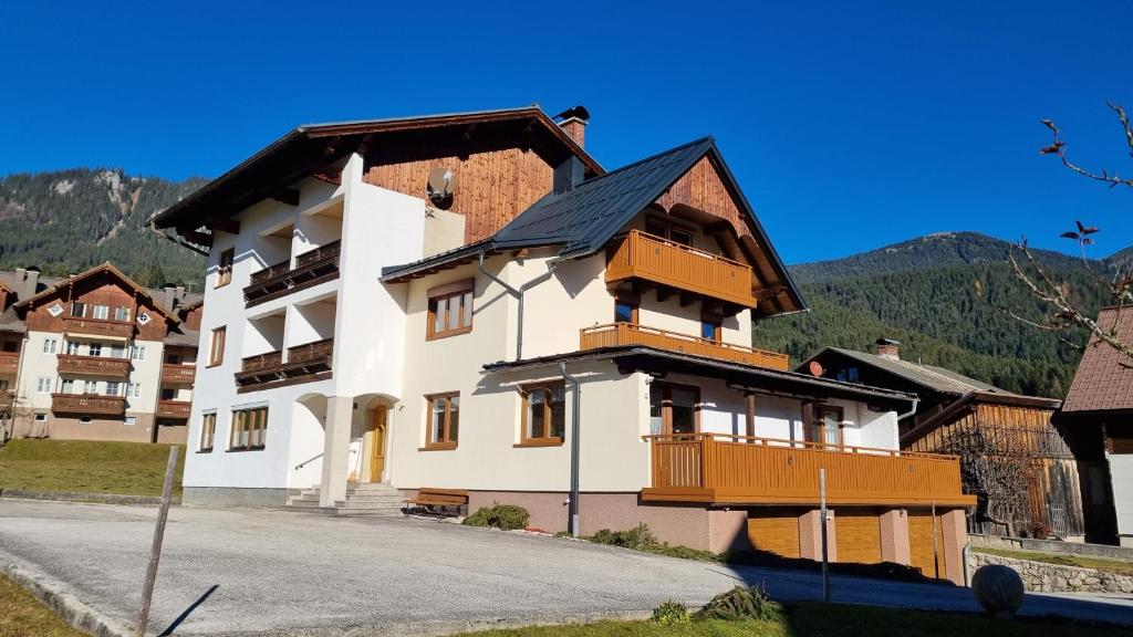 ein großes weißes Gebäude mit Balkon auf einer Straße in der Unterkunft Appartement Alpenblick in Gosau