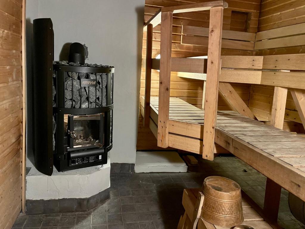 a wood burning stove in a room with a staircase at Houses by The Sea in Salpar