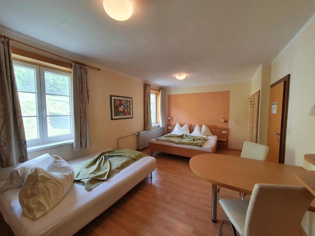 una camera d'albergo con due letti e un tavolo di Gasthof Zur Post a Ossiach