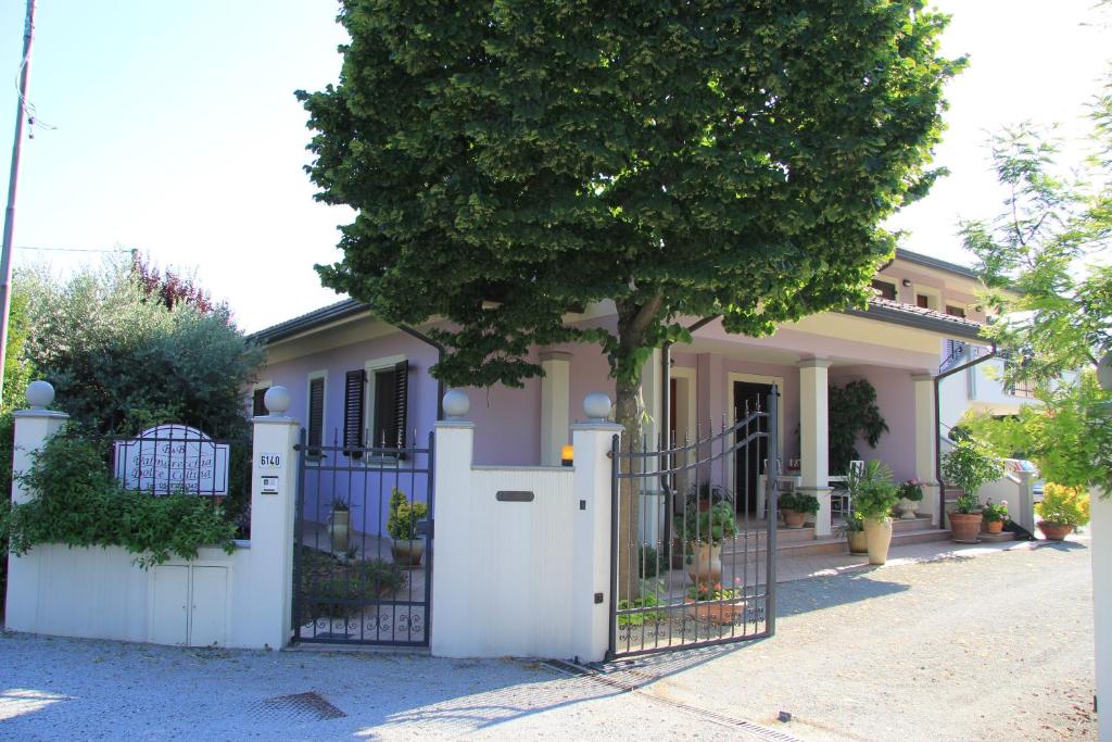 a house with a white gate and a tree at B&B Valmarecchia in Poggio Berni