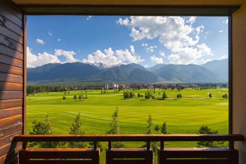 a view of a golf course from a window at The View Apartment, Terra Complex neighbour building in Bansko