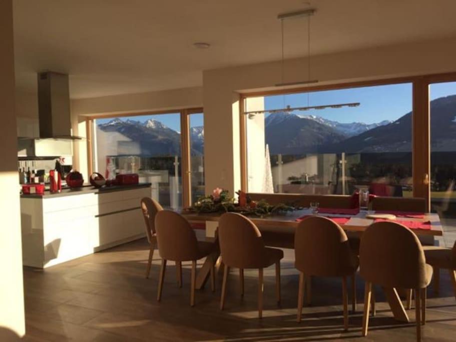 een keuken met een tafel en stoelen en uitzicht op de bergen bij Haus Clarysse in Schladming