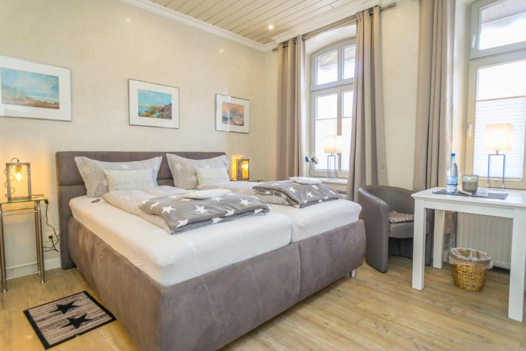 a bedroom with a large bed and a desk at Sterntaler in Westerland (Sylt)