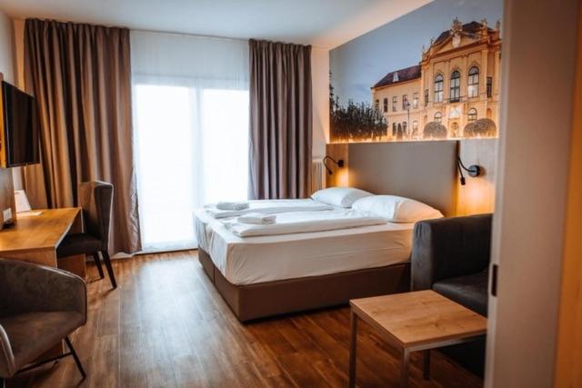 a hotel room with a bed and a living room at Hotel Am Sachsengang in Groß-Enzersdorf