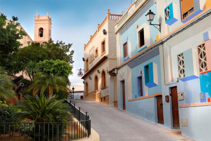 a narrow street with buildings and a clock tower at Home SEA&DREAMS OldTown II in Calpe