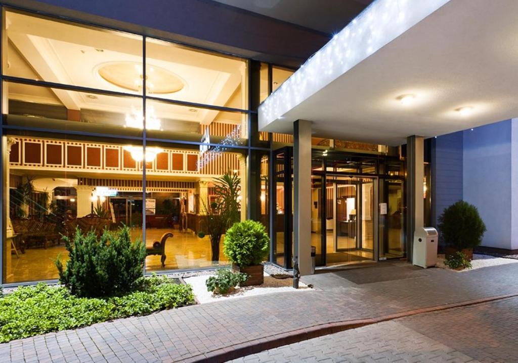 a large building with glass doors and a courtyard at Jasek Premium Hotel Wrocław in Wrocław