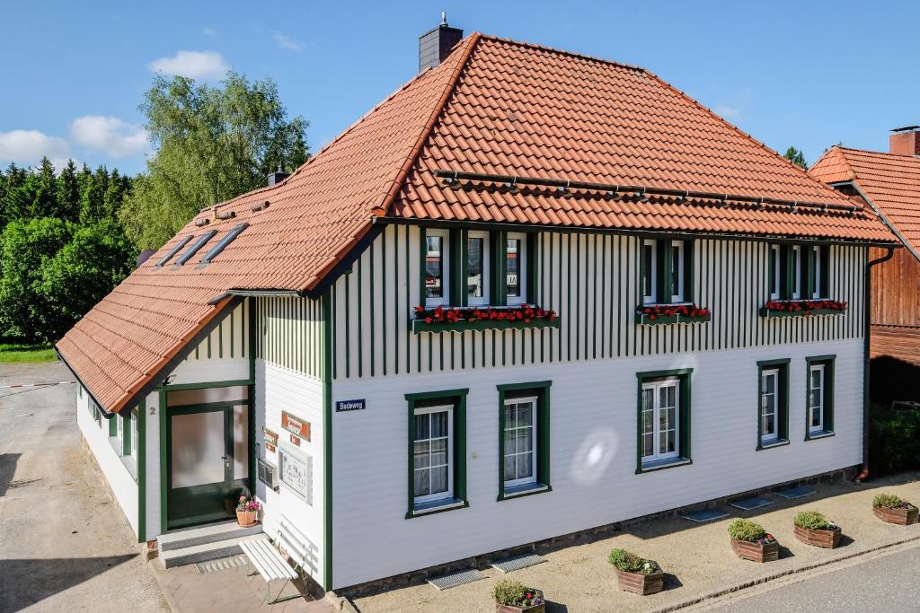 ein altes Haus mit orangefarbenem Dach in der Unterkunft Ferienwohnungen Gewiese in Schierke