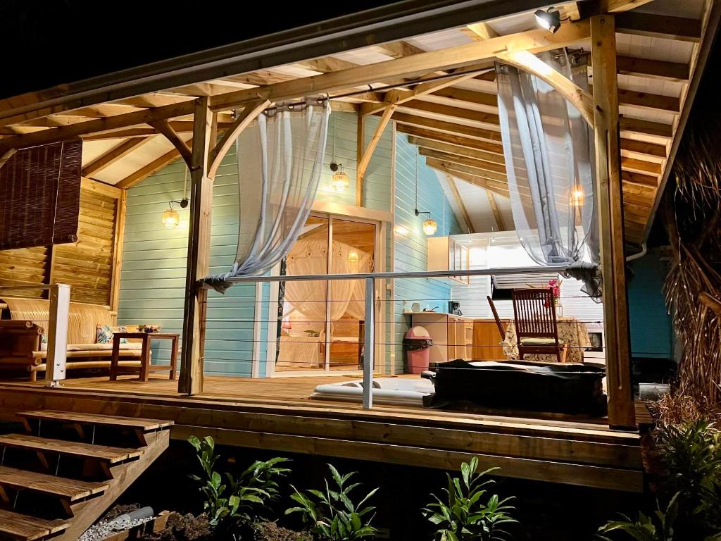 a screened in porch of a house at Villa Gaïa - Bungalow Ti-Spa et son jacuzzi privé dans un jardin tropical, séjour en amoureux ou en famille in Le Diamant